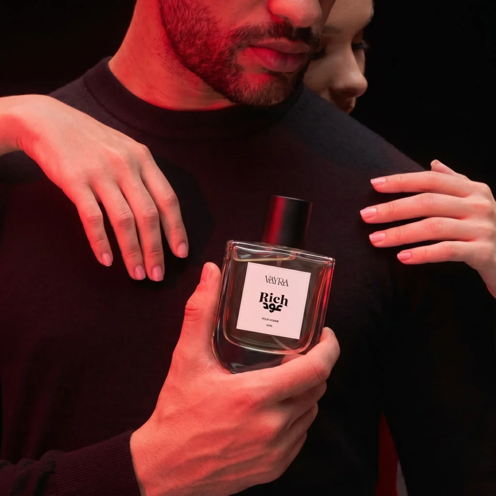 Man in black sweater holding Vayra Rich Oud with red rim lighting; best fragrance in Pakistan for date night.